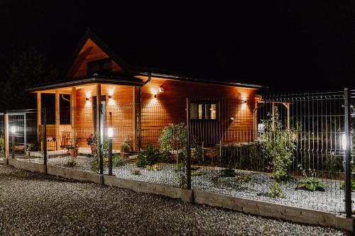a house with a fence in front of it at night at Regielskie Chaty in Regiel