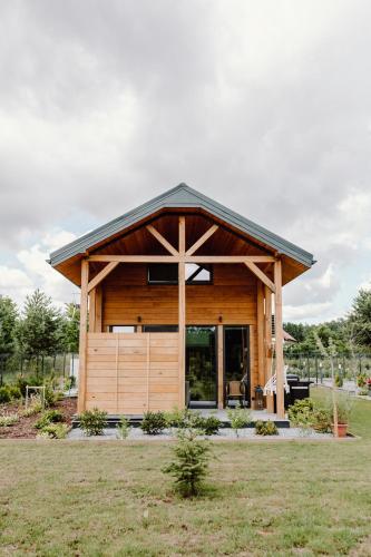 a small wooden cabin with a black roof at Regielskie Chaty in Regiel