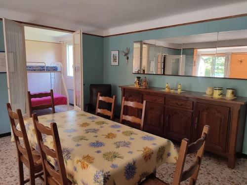 une salle à manger avec une table et une cuisine dans l'établissement Maison confortable avec grand jardin, à Courthézon