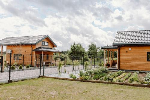 a home with a garden in front of a house at Regielskie Chaty in Regiel