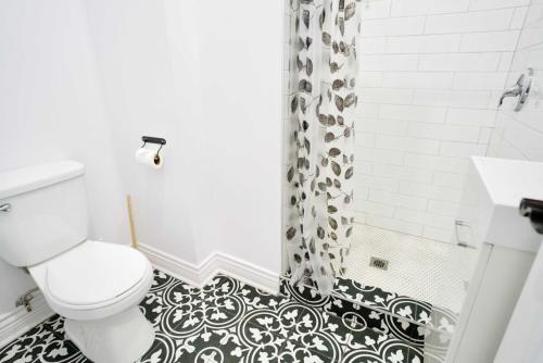 a black and white bathroom with a toilet and a shower at Le Mile End by M11 - Modern Studio in Montréal