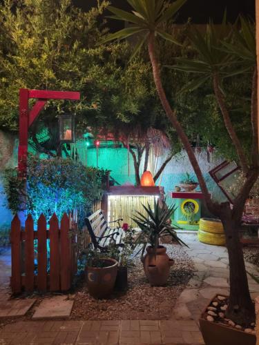 a garden at night with a fence and plants at The Bearded Dad Hostel in Tirana