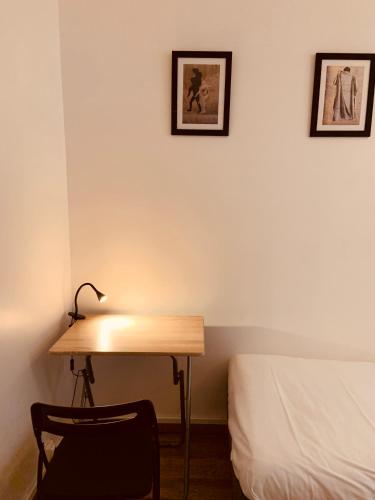 un bureau dans une chambre avec un lit et des photos encadrées dans l'établissement Studio Anvers, à Paris