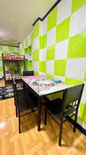 a room with a table and chairs and a bed at Deyo Guest House Room Green in Butuan