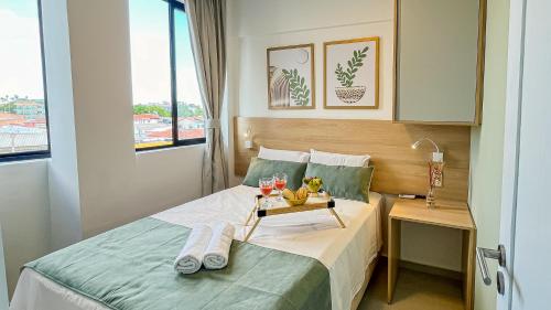 a hotel room with a bed with a tray of fruit on it at Flats no centro de Porto de Galinhas próximo à praia opções com e sem piscina privativa in Porto De Galinhas