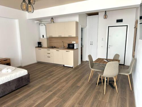 a room with a table and chairs and a kitchen at Nord Residence in Eforie Nord