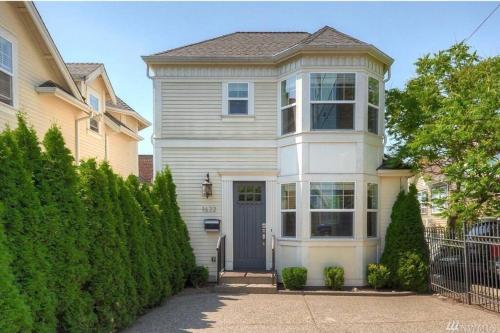 a large white house with a blue door at Adorable Cozy House with Parking and Loft! in Seattle