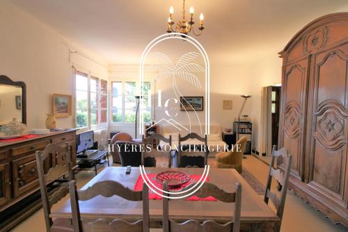 une salle à manger avec une table et un lustre dans l'établissement Les Grillons Pieds dans l'eau Beau Rivage By HC, à Carqueiranne