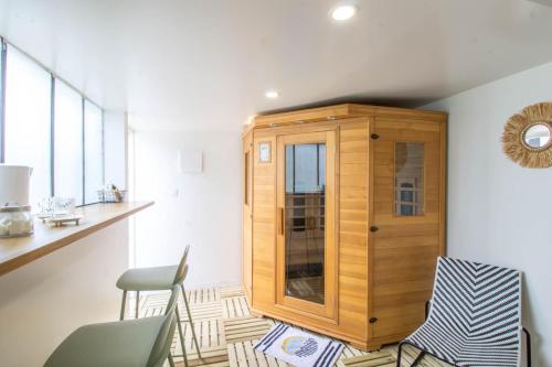 Cette chambre comprend une armoire en bois et une chaise. dans l'établissement Zen House New Spa & Sauna, à Mennecy