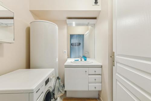 - une buanderie blanche avec lave-linge et sèche-linge dans l'établissement Appartement duplex dans le Saint Lambert by Weekome, à Paris