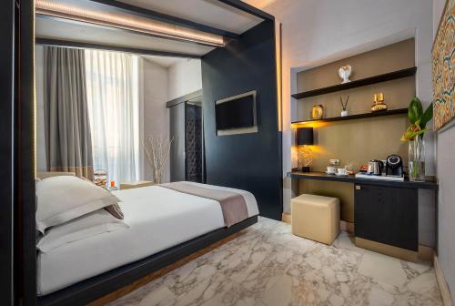 a bedroom with a large bed and a television at Dharma Luxury Hotel in Rome