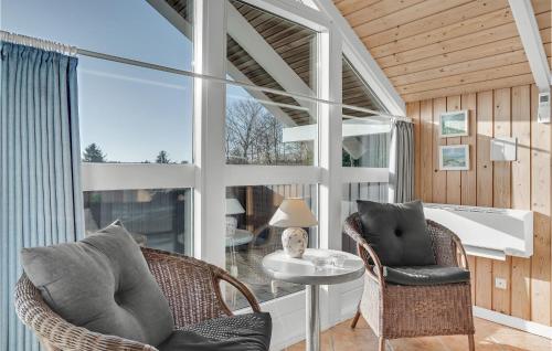 ブラーバンドにあるFour-Bedroom Holiday Home In Blavandの椅子2脚とテーブル1台と窓のある部屋