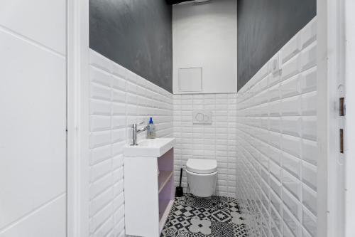 une salle de bain blanche avec un lavabo et des toilettes dans l'établissement Nice Renting - ROSSETTI - Modern Haven Heart of Old Nice, à Nice