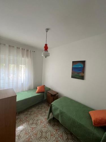 a room with two green beds and a window at B&B Villa Machi in Paola