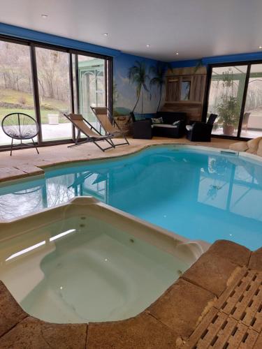 - une grande piscine au milieu d'une maison dans l'établissement GITE LA LAUZERAIE, à La Bourboule