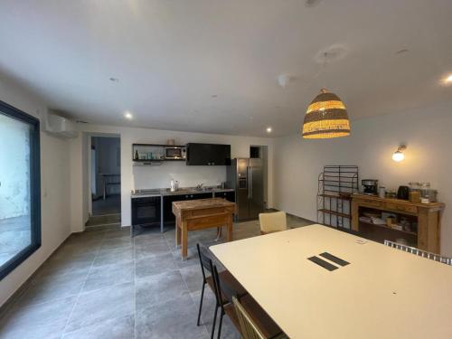 un salon avec une table et une cuisine dans l'établissement Appartement Maison Saint Laurent dAigouze Village tournage Ici Tout Commence, à Saint-Laurent-dʼAigouze