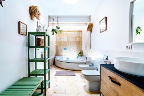 Un baño con bañera, inodoro y lavabo. en The Beach House - Central location - Private Plunge Pool - Roof Terrace - 100m to Beach, en Costa Teguise