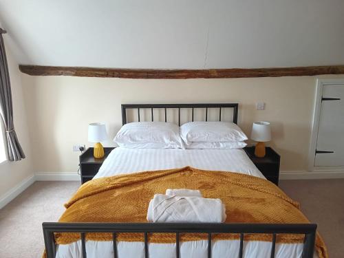 a bedroom with a bed with white sheets and pillows at Nelthorpe Arms in Barton upon Humber