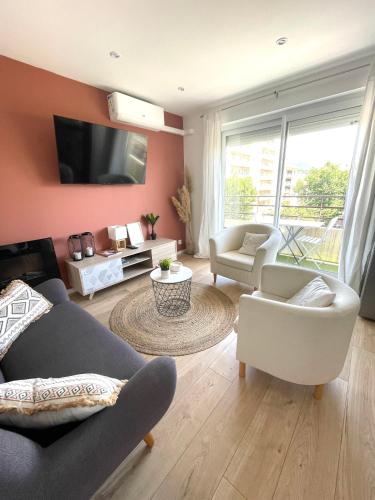 un salon avec un canapé, des chaises et une télévision dans l'établissement Le Terra-Cota 3 Ch privées 10' Gare-Port et Plage, WFI, Cosy, à Toulon