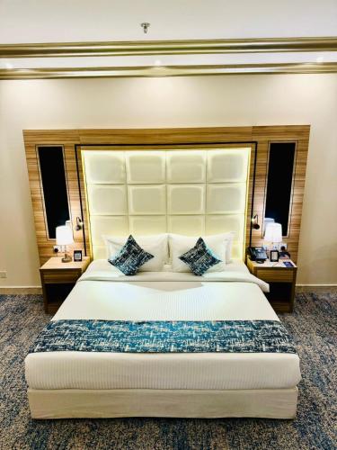 a bedroom with a large white bed with two tables at Casa Diora Hotel Al Naseem in Jeddah
