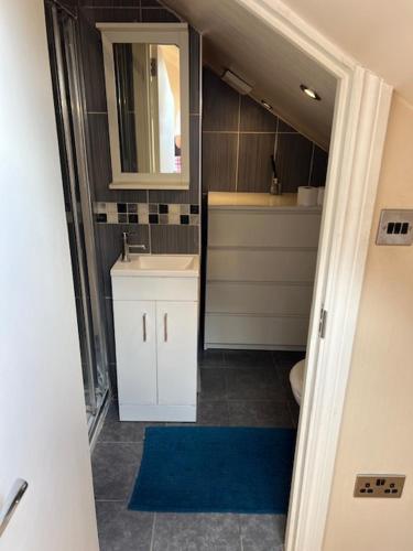 a bathroom with a sink and a mirror at Spacious and Modern En-suit in Harrow on the Hill