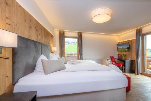 a bedroom with a large white bed in a room at Vitalhotel Sonnenhof in Going