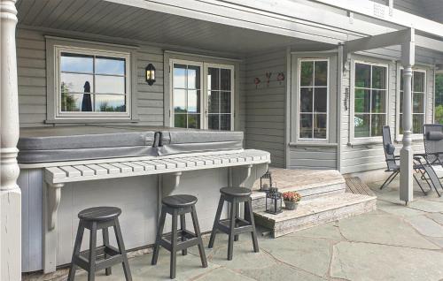 a outdoor bar with stools on a patio at Stunning Home In Lindesnes With Sauna in Svenevik