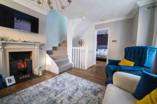 a living room with a blue couch and a fireplace at Stunning City centre Georgian townhouse - parking in Chester