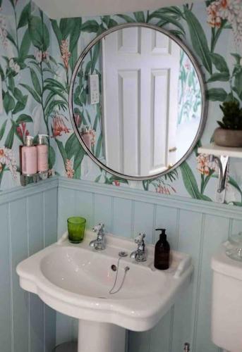 a bathroom with a sink and a mirror at Stunning City centre Georgian townhouse - parking in Chester