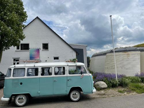 a blue and white van parked in front of a house at De Slaapfabriek vakantiehuis en trainingslocatie in Teuge