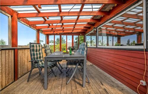 a patio with a table and chairs on a deck at 3 Bedroom Lovely Home In Karrebæksminde in Karrebæksminde