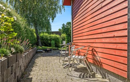 a group of chairs and tables against a red wall at 3 Bedroom Lovely Home In Karrebæksminde in Karrebæksminde