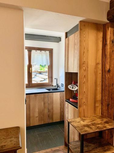 a kitchen with wooden cabinets and a table and a window at Maison Lalla in Pré-Saint-Didier