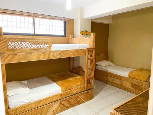 two bunk beds in a room with a window at Apartamento en tucacas Cocotero mar 2 con la playa a tus pies in Tucacas