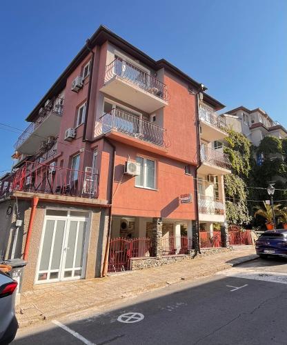 a red brick building with balconies on a street at Guest house Villa Stefi in Sozopol