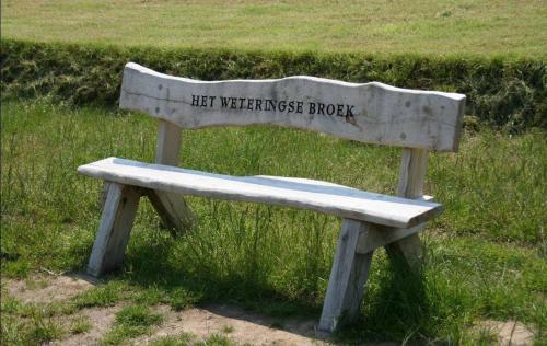a wooden bench with the words let weatheredswick brook on it at De Slaapfabriek vakantiehuis en trainingslocatie in Teuge
