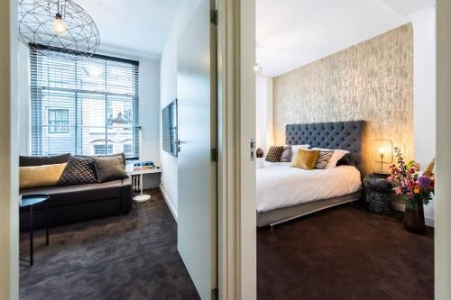 a bedroom with a large bed and a couch at Luxurious boutique suite in City Center in Amsterdam