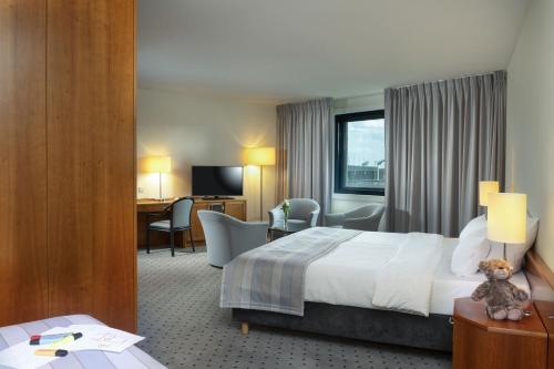 a hotel room with a bed and a desk at Maritim Airport Hotel Hannover in Hannover