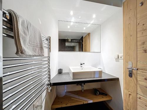 a bathroom with a sink and a mirror at Plein Ciel 118 **** in Verbier