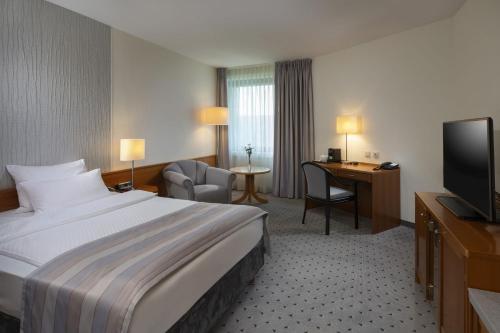 a hotel room with a bed and a television at Maritim Airport Hotel Hannover in Hannover