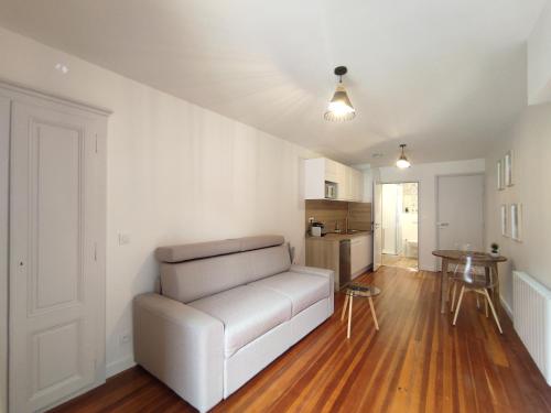un salon avec un canapé blanc et une table dans l'établissement Studio centre historique Thonon, à Thonon-les-Bains