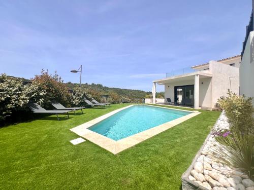 une piscine dans une cour à côté d'une maison dans l'établissement Villa contemporaine bord de mer Saint Aygulf, à Fréjus
