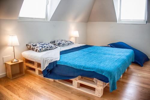 a bedroom with a bed with a blue blanket on it at The Nook Hostel in Ponta Delgada