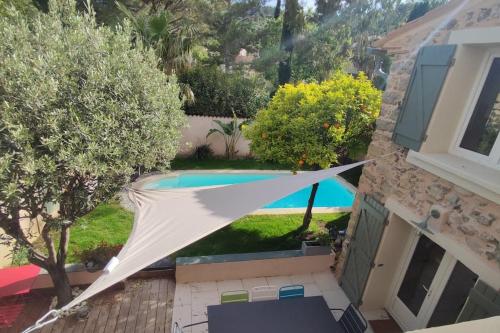 une vue d'une piscine avec un hamac dans une cour dans l'établissement Maison provençale en pierre avec piscine privée, à Cuers