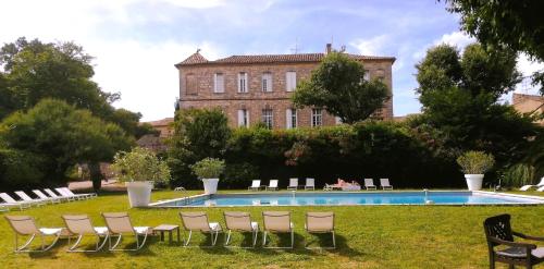 - un groupe de chaises assises dans l'herbe à côté d'une piscine dans l'établissement Château d'Arpaillargues - TERITORIA, à Arpaillargues-et-Aureillac