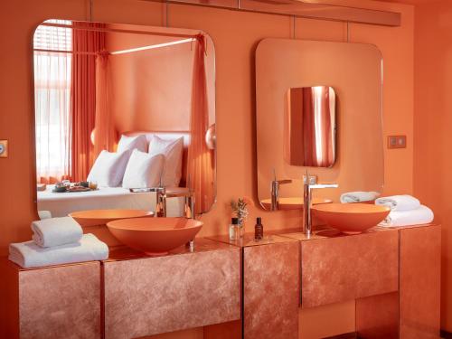 a bathroom with two sinks and a large mirror at Hotel OFF Paris Seine in Paris