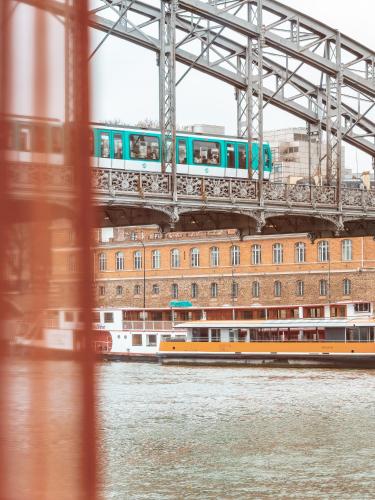 a train on a bridge over the water at Hotel OFF Paris Seine in Paris