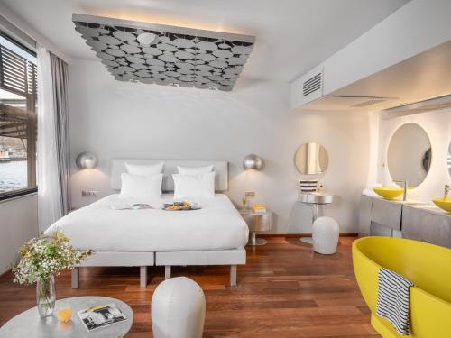 a bedroom with a white bed and a yellow chair at Hotel OFF Paris Seine in Paris