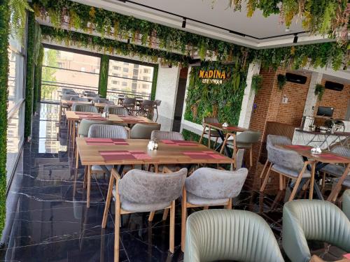 a restaurant with tables and chairs and ivy at Madina-ZamZam Halal Hotels Group in Baku