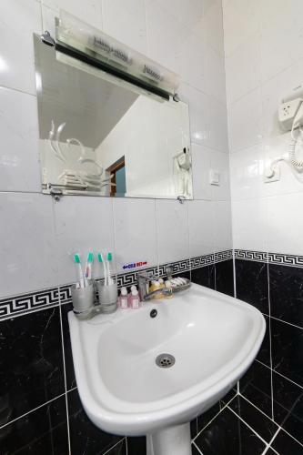 a bathroom with a white sink and a mirror at Qibla Tozabog in Khiva